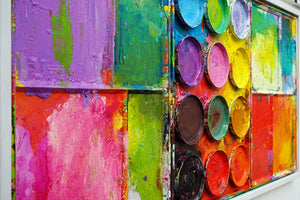 "Gleichgesinnte" aus der Seitenperspektive,  zeigt bunte Malerei auf einem überdimensionierten Farbkasten (95 x 195 x 5 cm). In den Mischfächer (außen) sind blaue, violette, grüne, gelbe, rote, pinke und orangene Farben zu sehen. In der Mitte befinden sich 12 Farbteller mit den üblichen Farben einer Palette. In den Zwischenräumen sind Farbkleckse und -flecken sichtbar. Moderne Wandskulptur. ARTLET | Atelier Hellbusch
