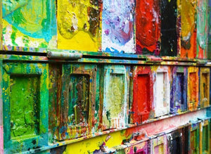 "Der Abschied" zeigt abstrakte Malerei auf einem großen Farbkasten (92 x 112 x 4 cm) aus der Seitenperspektive. In den Mischfächer (oben) sind Gelb, Blau, Grün, Rot, Schwarz und Ocker zu sehen. Unten befinden sich 16 quadratische Teller mit den üblichen Farben eines Farbkastens. In den Zwischenräumen sind Kleckse und Flecken sichtbar. Moderne Kunst vom Künstler Mark Hellbusch. ARTLET | Atelier Hellbusch