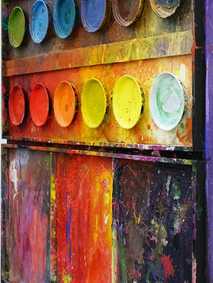 "Am Lagerfeuer", Malerei auf einem überdimensionierten Farbkasten (100x110 cm), aus der Seitenperspektive. In den Mischfächer (unten im Bild) sind vor allem Rot, Gelb, Blau und Schwarz zu sehen . Oben befinden sich 8 Farbteller mit den üblichen Farben eines Farbkastens. In den Zwischenräumen sind Farbkleckse und -flecken sichtbar. Diese Kunst wird in Wiesbaden angeboten. Abstraktes Kunstwerk. ARTLET | Atelier Hellbusch