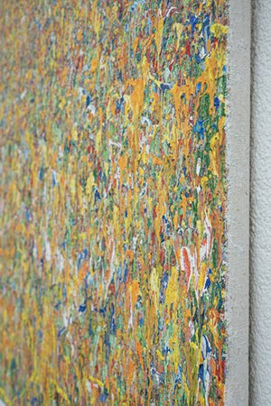 Claim 21 | Zeitgenössische Kunst auf Leinwand (80 x 100 cm) für moderne Wohnräume. Bunte Farben - insbesondere ocker aber auch gelb, weiß, grün, blau, orange sowie deren Vermischungen ergeben ein abstraktes Farbfeld. Oben im Bild sind bunte Farbpunkte zu sehen. Nach unten hin verwandeln sich die Punkte in Farbstriche. Die Striche werden immer Länger, so dass das abstrakte Bild an eine Wiese erinnert. Seitenperspektive. ARTLET - Atelier Hellbusch.