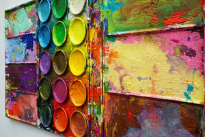 "Die Reise" zeigt bunte Malerei auf einem überdimensionierten Farbkasten (100 x 200 x 4 cm) aus der Seitenperspektive. In den Mischfächer (außen) sind blaue, violette, grüne, gelbe und graue Farben zu sehen. In der Mitte befinden sich 15 Farbteller mit den üblichen Farben einer Palette. In den Zwischenräumen sind Farbkleckse und -flecken sichtbar. Großformatige Kunst. ARTLET | Atelier Hellbusch