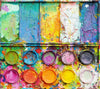 "In den Bergen" zeigt moderne Kunst auf dem Farbkasten (64 x 72 cm). In den Mischfächer (oben) sind bunte Farben zu sehen: Frühlingsfarben in orange, grün, blau, violet und weiß. Unten befinden sich 10 Farbteller mit der typisch bunten Palette der Farben eines Farbkastens. In den Zwischenräumen sind Farbkleckse und -flecken sichtbar. Die Malerei wurde experimentell umgesetzt. Abstrakte Malerei. ARTLET - Atelier Hellbusch.