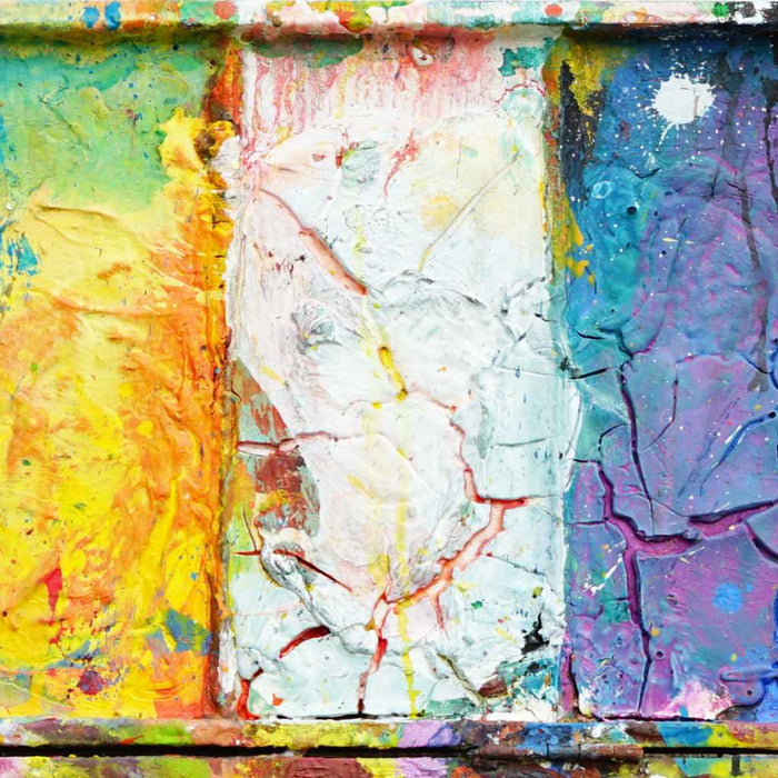 "In den Bergen" zeigt moderne Kunst auf dem Farbkasten (64 x 72 cm, Ausschnitt). In den Mischfächer (oben) sind bunte Farben zu sehen: Frühlingsfarben in orange, grün, blau, violet und weiß. Unten befinden sich 10 Farbteller mit der typisch bunten Palette der Farben eines Farbkastens. In den Zwischenräumen sind Farbkleckse und -flecken sichtbar. Die Malerei wurde experimentell umgesetzt. Abstrakte Malerei. ARTLET - Atelier Hellbusch.