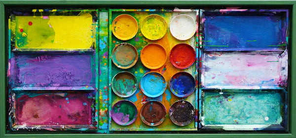 "Jungle" zeigt abstrakte Malerei auf dem Farbkasten (eingerahmt 65 x 135 cm) und ergibt ein Wandobjekt. In den Mischfächern (rechts) sind blaue und weiße Farbtöne zu erkennen. Ganz links Gelb, Violett und Bordeaux. In der Mitte befinden sich 12 Farbteller mit den typischen Farben der Palette. In den Zwischenräumen sind Farbkleckse und -flecken sichtbar. Es wurde experimentell gemalt. Moderne Kunst.  ARTLET | Atelier Hellbusch.