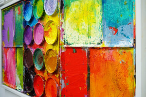 "Gleichgesinnte" aus der Seitenperspektive, zeigt bunte Malerei auf einem überdimensionierten Farbkasten (95 x 195 x 5 cm). In den Mischfächer (außen) sind blaue, violette, grüne, gelbe, rote, pinke und orangene Farben zu sehen. In der Mitte befinden sich 12 Farbteller mit den üblichen Farben einer Palette. In den Zwischenräumen sind Farbkleckse und -flecken sichtbar. Moderne Wandskulptur. ARTLET | Atelier Hellbusch