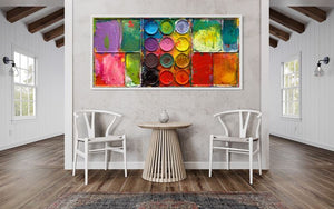"Gleichgesinnte" zeigt bunte Malerei auf einem überdimensionierten Farbkasten (95 x 195 x 5 cm). In den Mischfächer (außen) sind blaue, violette, grüne, gelbe, rote, pinke und orangene Farben zu sehen. In der Mitte befinden sich 12 Farbteller mit den üblichen Farben einer Palette. In den Zwischenräumen sind Farbkleckse und -flecken sichtbar. Moderne Wandskulptur. ARTLET | Atelier Hellbusch