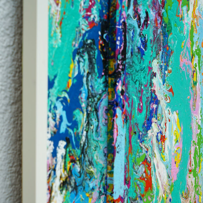 RE 21 zeigt ein abstraktes Farbrelief aus Türkis, Rosa, Gelb, Schwarz und Weiß – entstanden aus aufgefangener Farbe, gerahmt in Weiß mit räumlicher Tiefe (Seitenaufnahme). Atelier Hellbusch.