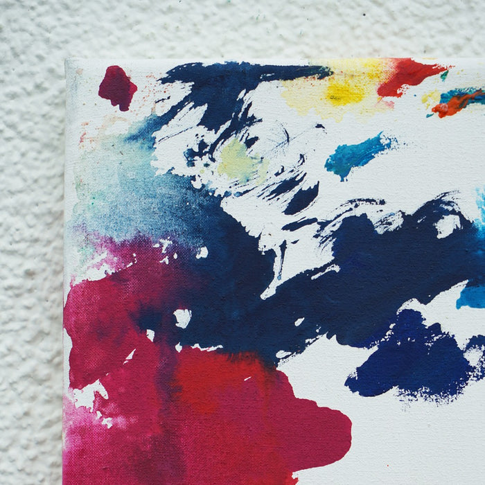 RE 22 zeigt spontane, farbige Spuren auf weißem Grund – ein abstraktes Werk mit roten, gelben, blauen und grünen Farbflächen auf Leinwand, 30x24cm, 2025 (Ausschnitt). Atelier Hellbusch.