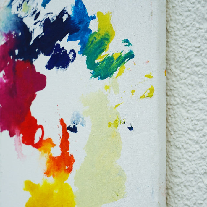 RE 22 zeigt spontane, farbige Spuren auf weißem Grund – ein abstraktes Werk mit roten, gelben, blauen und grünen Farbflächen auf Leinwand, 30x24cm, 2025 (Seitenperspektive). Atelier Hellbusch.