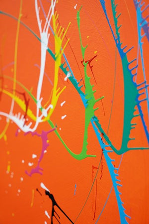 Gemälde Splash 42: Große, runde Leinwand mit orangem Hintergrund und dynamischen, bunten Farbspritzern in Weiß, Gelb, Grün, Blau, Rot und Schwarz. Moderne, experimentelle Kunst von 2024 (Nahaufnahme, seitlich). ARTLET - Atelier Hellbusch