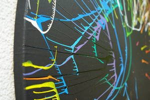 Gemälde Splash 49: Große, runde Leinwand mit tiefschwarzem Hintergrund und dynamischen, bunten Farbspritzern in Blau, Grün, Gelb, Orange, Rot und Weiß. Moderne, experimentelle Kunst von 2024. (Seitenansicht)