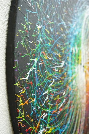 Gemälde Splash 59 (Seitenansicht): Runde Leinwand mit einem tiefschwarzen Hintergrund und dynamischen Farbspritzern in Weiß, Grün, Blau, Gelb, Rot und Orange. Zeitgenössische, abstrakte Kunst gemalt 2024 von Mark Hellbusch