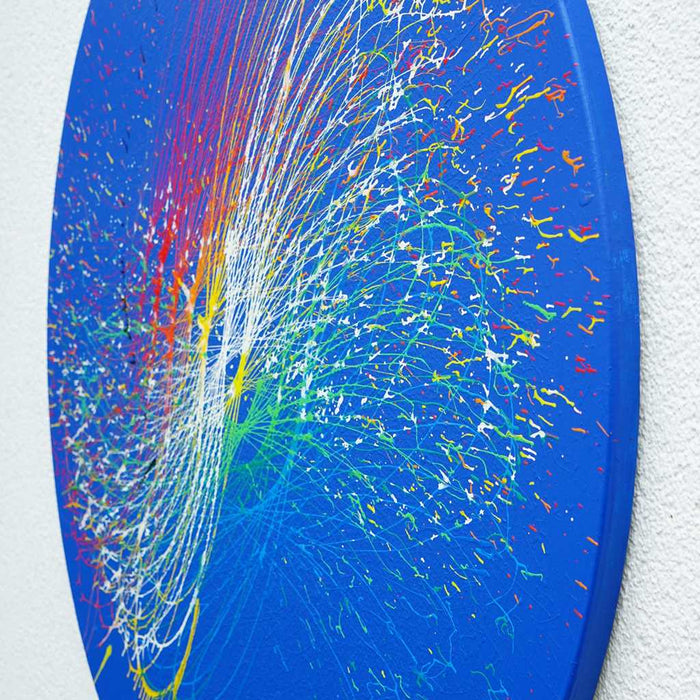 Ein lebendiges, rundes Kunstwerk namens "Splash 64" (Seitenperspektive) mit einer farbenfrohen Explosion aus Rot, Gelb, Grün und Weiß auf einem blauen Hintergrund, geschaffen von Atelier Hellbusch.