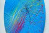 "Splash 65" (Seite), ein rundes Gemälde mit einem Durchmesser von 120 cm, zeigt eine lebendige Mischung aus blauen, roten, gelben, grünen und weißen Farbspritzern, die Dynamik und Eleganz vereinen. Kunstwerk des Atelier Hellbusch.