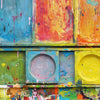"Unterwegs III" zeigt zeitgenössische experimentelle Malerei (92x80x3 cm) auf einem Wandobjekt (Farbkasten). In den Mischfächer (unten) sind blaue, orangene, gelbe, weiße, schwarze und pinke Farben zu sehen. Oben befinden sich 9 Farbteller mit den üblichen bunten Farben eines Farbkastens. In den Zwischenräumen sind Farbkleckse und -flecken sichtbar. Diese experimentelle Malerei - schön, bunt und modern - kann man zum realistischen Preis online bestellen. Zeitgenössische Malerei. ARTLET - Atelier Hellbusch