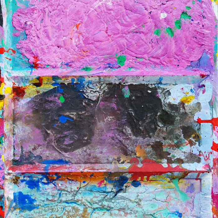 Das Gemälde "Unterwegs" (Ausschnitt) ist ein überdimensionierter, benutzter Farbkasten 130 x 60 x 5 cm groß. Das Kunstwerk ist mit einem weißen Rahmen versehen (Schattenfuge, weiß, ca 2 cm Breite). In den Mischfächer sind Blau, Violett, Grün, Braun und Gelb zu sehen. In der Mitte befinden sich 12 Farbfächer mit den üblichen Farben einer Palette. In den Zwischenräumen sind Farbkleckse und -flecken sichtbar. Modernes Bild als Wandskulptur. ARTLET - Atelier Hellbusch