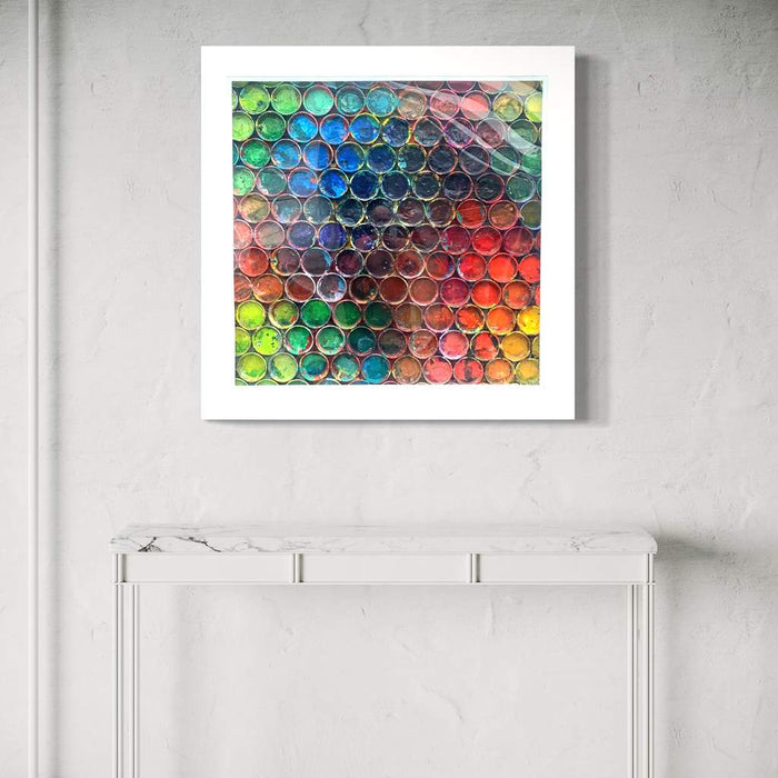 Großes, buntes Kunstobjekt für die Wand „RE 15“ mit plastischen Farbkreisen auf 123x123x10 cm (in Situation). Wandskulptur hinter Plexiglas aus der Serie „Reste eines Experiments“. Künstler Mark Hellbusch, 2024.