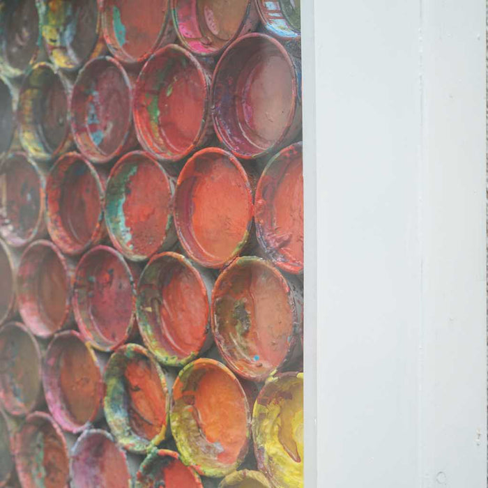 Großes, buntes Kunstobjekt für die Wand „RE 15“ mit plastischen Farbkreisen auf 123x123x10 cm (Seitenaufnahme). Wandskulptur hinter Plexiglas aus der Serie „Reste eines Experiments“. Künstler Mark Hellbusch, 2024.