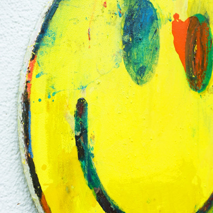 Smiley I (Seitenperspektive) – rundes Gemälde mit gelbem Smiley aus der Serie Schmiertafel von Mark Hellbusch