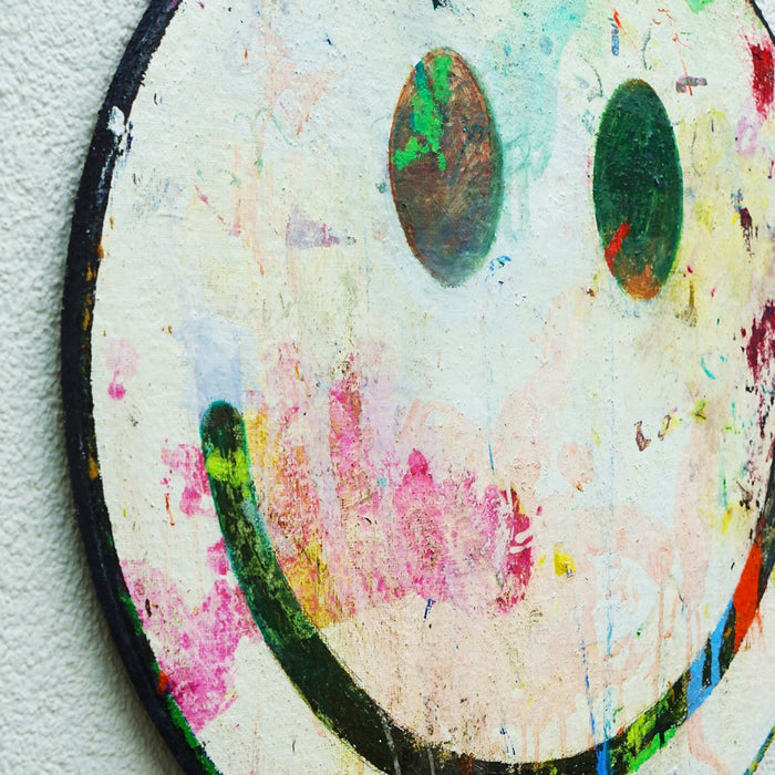 Rundes Smiley Gemälde (von der Seite) mit zarter weißer Fläche und dunklem Lächeln aus der Serie Schmiertafel von Mark Hellbusch