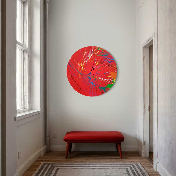 Modernes, rundes Bild Splash 55 (in situ): Rote Leinwand mit dynamischen Farbspritzern in Blau, Grün, Gelb, Orange und Weiß. Zeitgenössische, abstrakte Kunst von Mark Hellbusch, 2024.