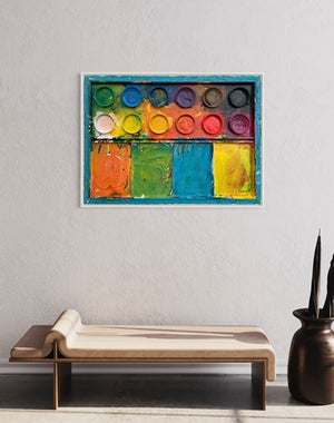 "Der Sommer" zeigt moderne Kunst auf dem Farbkasten (80 x 110 cm), präsentiert im Raum (App Smatist). In den Mischfächer (unten) sind bunte Farben zu sehen: orange, grün, blau und gelb. Oben befinden sich 12 Farbteller mit der typischen Palette der Farben eines Farbkastens. In den Zwischenräumen sind Farbkleckse und -flecken sichtbar. Die Malerei wurde experimentell umgesetzt. Abstraktes Gemälde. ARTLET | Atelier Hellbusch.