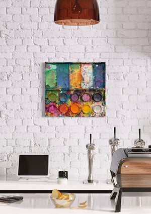 "In den Bergen" zeigt moderne Kunst auf dem Farbkasten (64 x 72 cm), präsentiert im Raum (Smartist App). In den Mischfächer (oben) sind bunte Farben zu sehen: Frühlingsfarben in orange, grün, blau, violet und weiß. Unten befinden sich 10 Farbteller mit der typisch bunten Palette der Farben eines Farbkastens. In den Zwischenräumen sind Farbkleckse und -flecken sichtbar. Die Malerei wurde experimentell umgesetzt. Abstrakte Malerei. ARTLET | Atelier Hellbusch.