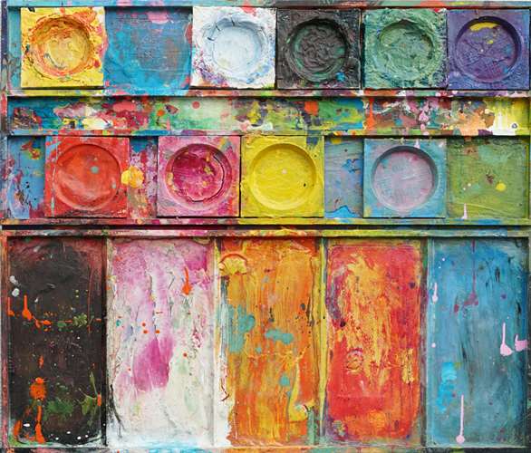 "Unterwegs III" zeigt zeitgenössische experimentelle Malerei (92x80x3 cm) auf einem Wandobjekt (Farbkasten). In den Mischfächer (unten) sind blaue, orangene, gelbe, weiße, schwarze und pinke Farben zu sehen. Oben befinden sich 9 Farbteller mit den üblichen bunten Farben eines Farbkastens. In den Zwischenräumen sind Farbkleckse und -flecken sichtbar. Diese experimentelle Malerei - schön, bunt und modern - kann man zum realistischen Preis online bestellen. Zeitgenössische Malerei. ARTLET | Atelier Hellbusch