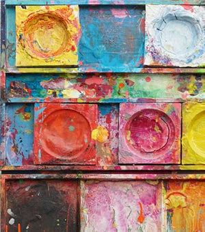 "Unterwegs III" zeigt zeitgenössische experimentelle Malerei (92x80x3 cm) auf einem Wandobjekt (Farbkasten). In den Mischfächer (unten) sind blaue, orangene, gelbe, weiße, schwarze und pinke Farben zu sehen. Oben befinden sich 9 Farbteller mit den üblichen bunten Farben eines Farbkastens. In den Zwischenräumen sind Farbkleckse und -flecken sichtbar. Diese experimentelle Malerei - schön, bunt und modern - kann man zum realistischen Preis online bestellen. Zeitgenössische Malerei. ARTLET | Atelier Hellbusch