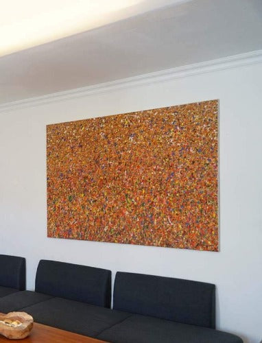 Claim 65 | Moderne großformatige Kunst auf Leinwand 120 x 160 cm. Bunte Farben - insbesondere Rot, Gelb, Orange, Weiß, Blau sowie deren Vermischungen ergeben ein organisches Feld. Der Verlauf der Farben ist oben eher punktartig. Nach unten hin wird der Verlauf der Farben auf dem Gemälde immer länger, also strichartig. So entsteht ein modernes, räumliches Bild, dass an Natur erinnert. Präsentiert im Wohnzimmer. Großformatige Kunst ARTLET | Atelier Hellbusch.