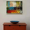 "Kreta" zeigt ein schönes abstraktes Bild in Form eines Farbkastens (Präsentiert über Sideboard). Zu sehen ist das Gemälde in Wiesbaden. In den Mischfächer (oben) sind olivene, grüne, weiße, blaue beige und schwarze Farben. Unten befinden sich 14 Farbteller mit den bunten Farben eines Farbkastens. In den Zwischenräumen sind Farbkleckse und -flecken sichtbar. Diese bunte, moderne Malerei auf dem Wandobjekt kann man zum realistischen Preis online kaufen. Schönes Bild. ARTLET | Atelier Hellbusch.
